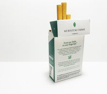 Load image into Gallery viewer, Product displayed resembles a white classic cigarette pack with a large seed/stem logo that is various shades of textured green.  The company logo is on the front flap and the text is in green label with font Manrope.  The pack is shown at an angle with the back panel facing out.  The text describes the story of the smokes.  There is a small hemp leaf dividing the paragraphs